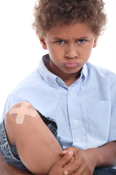 Kleine jongen met gips op knie — Stockfoto