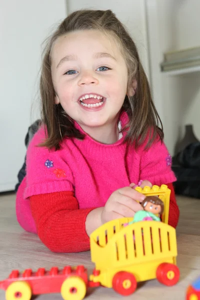 Девочка играет с игрушками на полу — стоковое фото