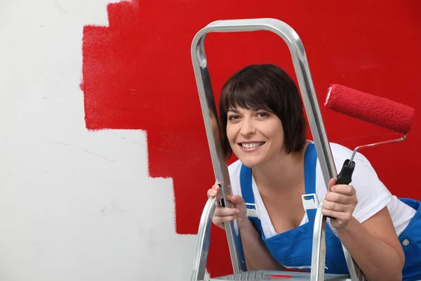 Brunette schilderij muur in het rood — Stockfoto