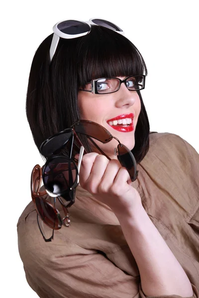 Woman wearing glasses and holding multiple sunglasses Stock Photo