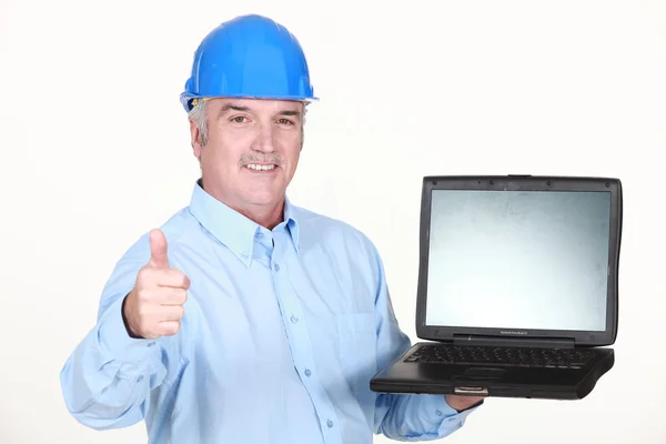 Pulgares hacia arriba de un ingeniero con una computadora portátil Fotos de stock libres de derechos