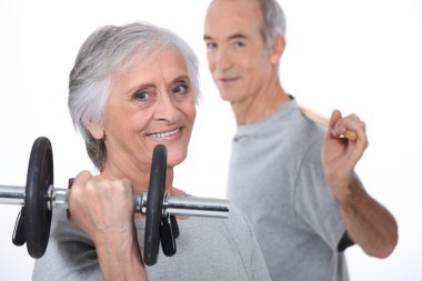 Grey-haired couple lifting weights clipart