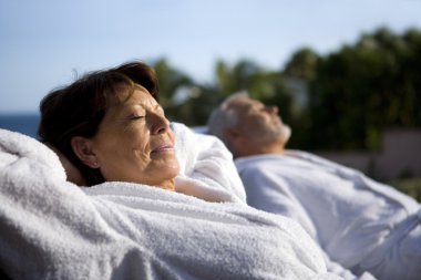 Couple laying outside in bathing robes clipart