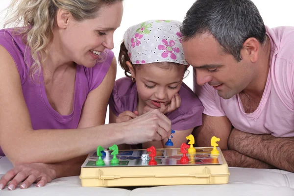Família jogando um jogo de tabuleiro juntos — Fotografia de Stock