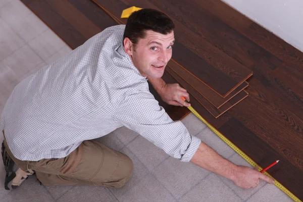 寄せ木張りの床を敷設男 — ストック写真