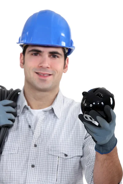 Construction worker holding a piggy bank — Stock Photo, Image