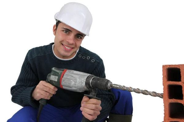 Man drilling through brick — Stock Photo, Image