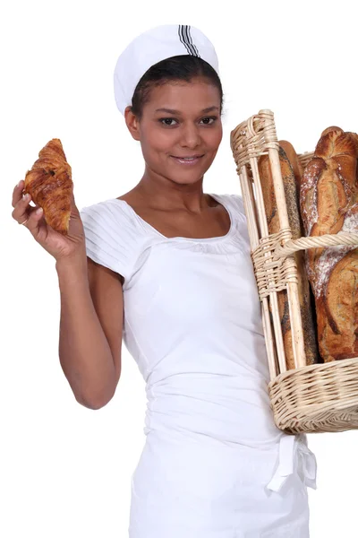 A baker with her bread and a croissant — Stock Photo, Image