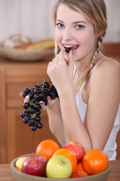 Kvinna äta druvor — Stockfoto