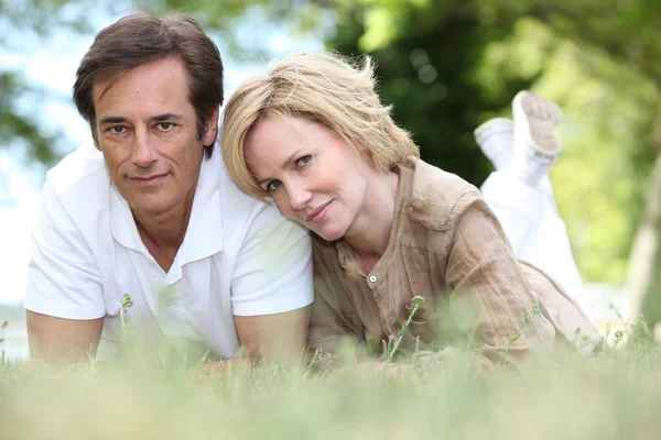 A loving couple lying on the grass — Stock Photo, Image