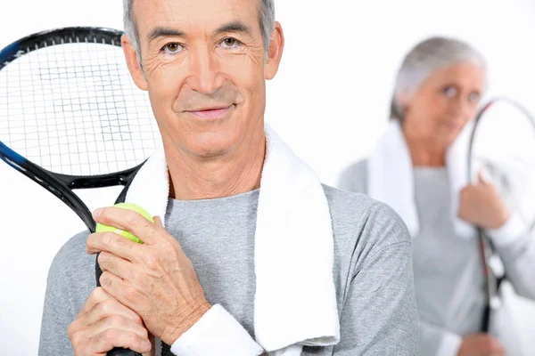 Elderly couple playing tennis together — Stock Photo, Image