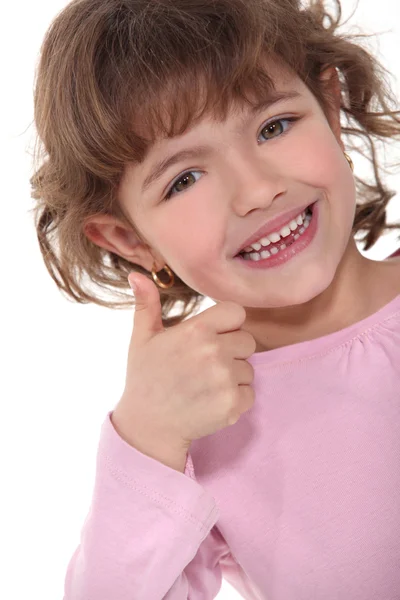 Усміхнена маленька дівчинка піднімає великі пальці — стокове фото