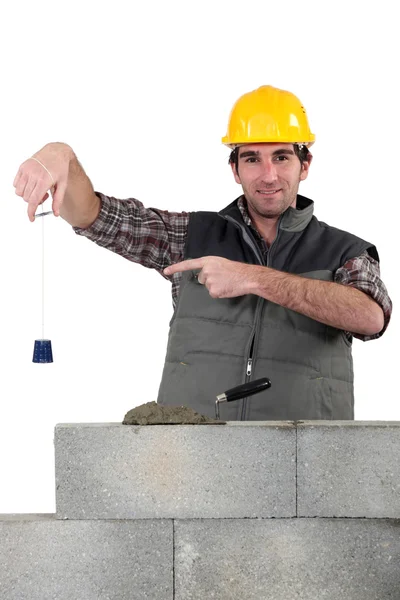 Bricklayer checking that wall is level — Stock Photo, Image