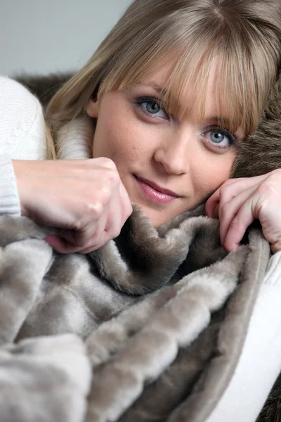 Mulher loira relaxante sob cobertor — Fotografia de Stock