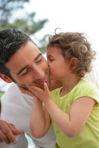 Klein meisje kussen van haar vader — Stockfoto