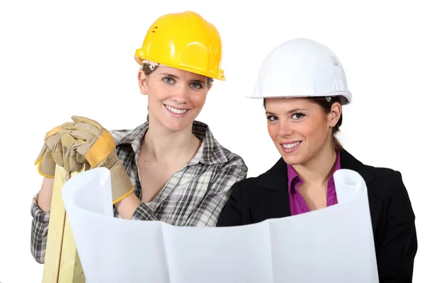 Hantverkerska och affärskvinna tittar på en plan — Stockfoto