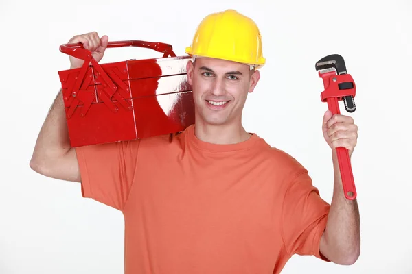 Craftsman carrying toolbox over his shoulder and spanner — Stock Photo, Image
