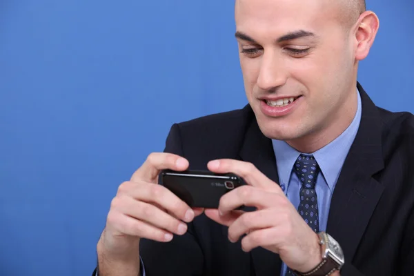 Mladý holohlavý vypadající mobilní telefon obrazovka — Stock fotografie