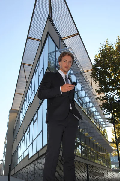 Ügyvezető, háromszög alakú épület előtt — Stock Fotó