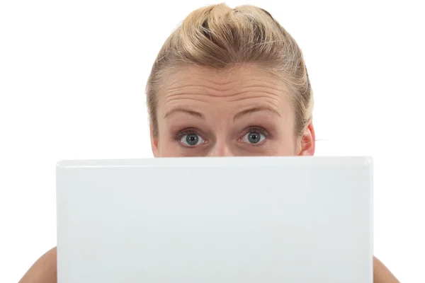 Förvånad kvinna med en bärbar dator Stockbild