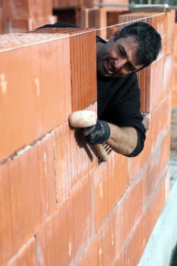 Man building a brick wall clipart