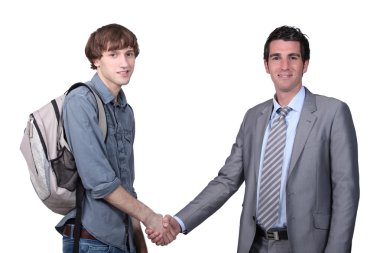 Teenager shaking hands with a man in a suit clipart