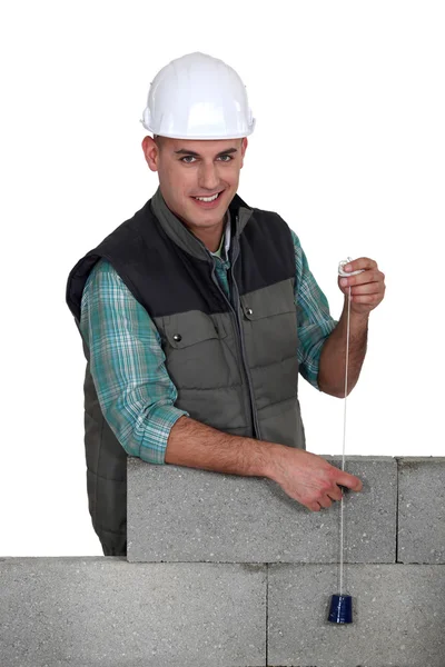 Tradesman holding a plumbline — Stock Photo, Image