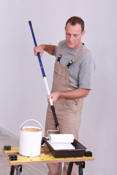 Homem aplicando tinta ao rolo — Fotografia de Stock