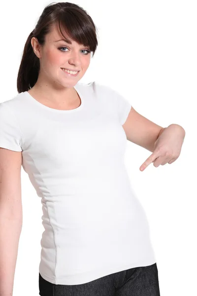 Fiatal nő mutatva rá fehér póló — Stock Fotó