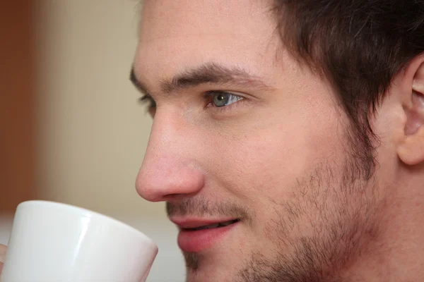 Fechar de um jovem com uma caneca — Fotografia de Stock