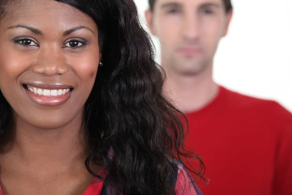 Smiling woman standing in front of a man — Stock Photo, Image
