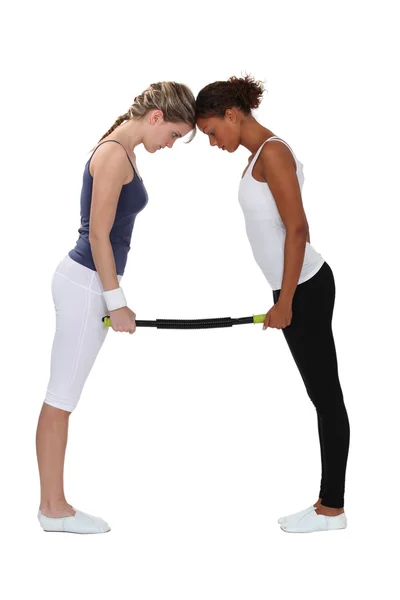 Mulheres dobrando uma barra de fitness aeróbica — Fotografia de Stock
