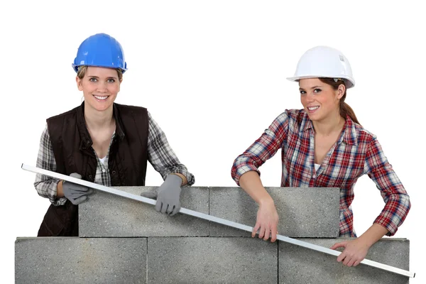 Trabalhadoras da construção feminina levantando uma barra — Fotografia de Stock