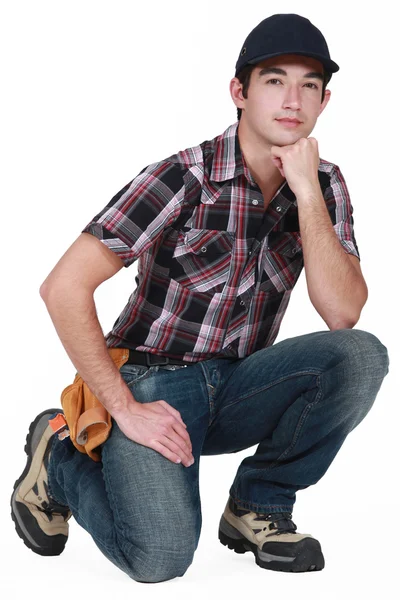 Portrait of young craftsman wearing cap with face resting on fist — Stock Photo, Image