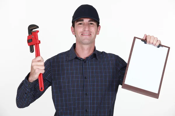 Loodgieter houden moersleutel en clip board — Stockfoto