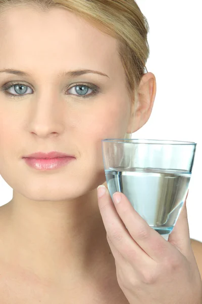 Блондинка со стаканом воды в руке — стоковое фото