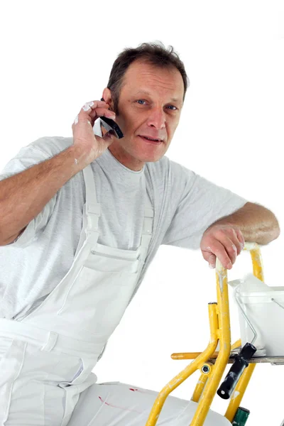 Decorador fazendo um telefonema enquanto subia uma escada — Fotografia de Stock