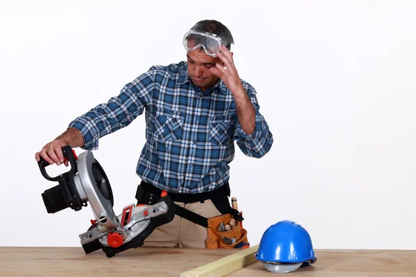 Craftsman looking at his new electric saw — Stock Photo, Image