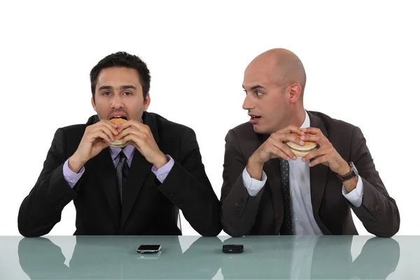 Zakenlieden eten hamburgers — Stockfoto