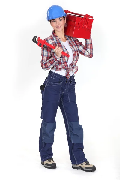 Mujer sosteniendo una caja de herramientas y una llave de tubo — Foto de Stock