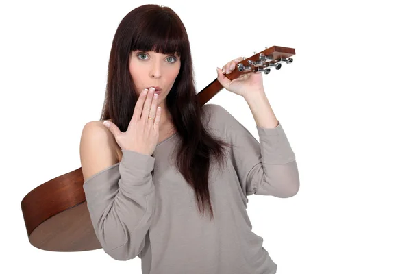 Young woman carrying guitar over shoulder with hand before mouth Royalty Free Stock Photos