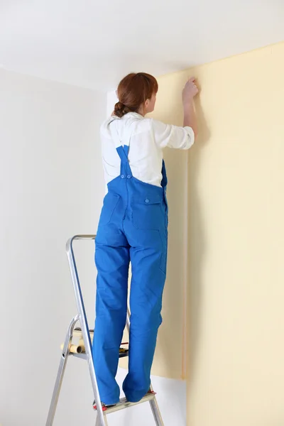 Young woman laying wall paper — Stock Photo, Image