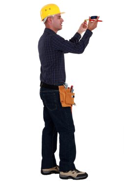 A male construction worker taking measures. clipart