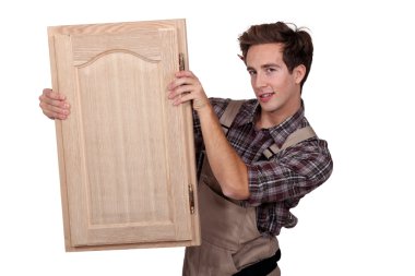 A carpenter holding a closet door. clipart