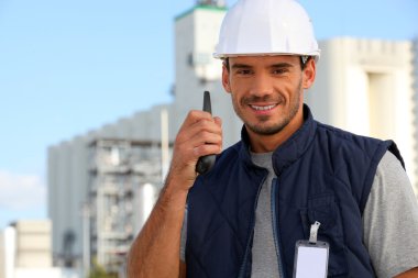 Construction worker speaking into his walkie-talkie clipart