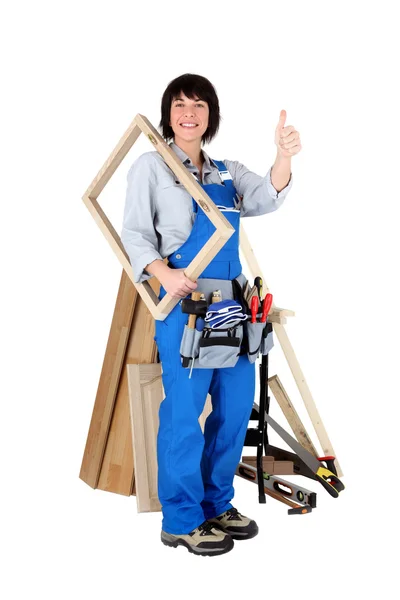 Female carpenter holding wooden frame — Stock Photo, Image