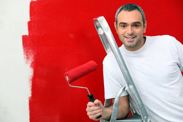 赤い壁を塗る人 — ストック写真