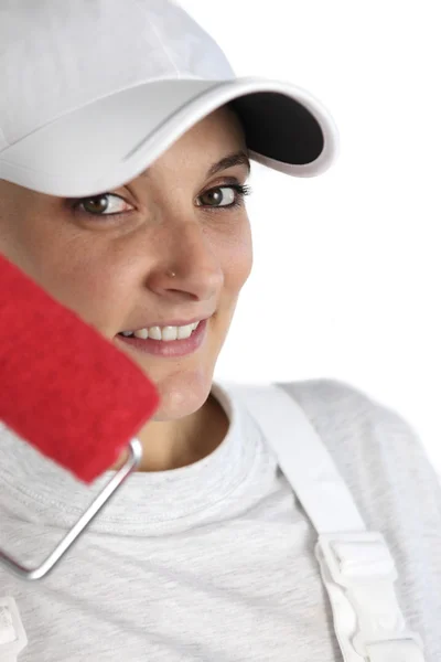 Bust shot portrait of female house painter with red roller and cap — Stock Photo, Image
