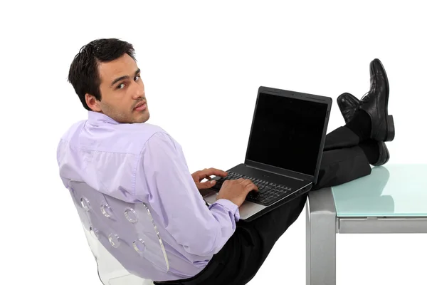 Mężczyzna odpoczynek nogi na biurko szklane — Zdjęcie stockowe