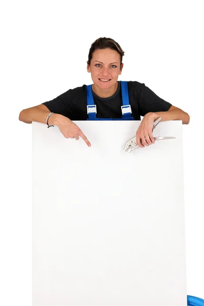 Eletricista feminina apontando para placa em branco — Fotografia de Stock